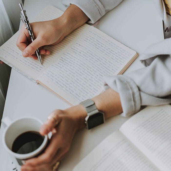 Man writing while drinking coffee